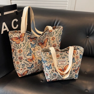 Floral jacquard tote bag set with butterfly patterns and cotton handles on a sofa