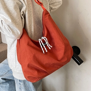 Grande borsa a tracolla in tela rosso mattone con corda intrecciata e etichetta moda