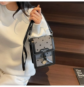 Détail du sac de téléphone vintage à pois avec anneau en métal et sangle en cuir