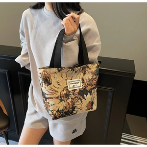 Detail of vintage floral jacquard tote bag with black nylon handles and brand label