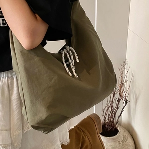 Grande borsa a tracolla in tela verde oliva con coulisse e un design minimalista