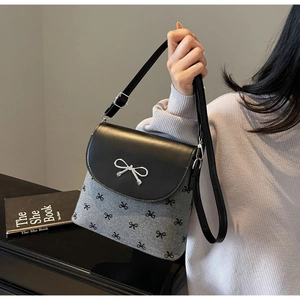 Détail du sac bandoulière avec imprimés nœuds noirs et boucle en métal argenté