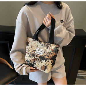 Close-up of vintage floral jacquard tote bag featuring a white label and canvas handles