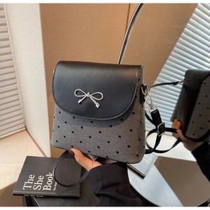 Détail d'un sac à nœud avec motifs de cœurs et fermoir métallique en forme de nœud
