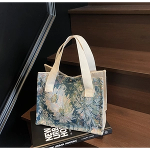 Detail of floral jacquard embroidery texture and cotton ribbon handle on tote bag