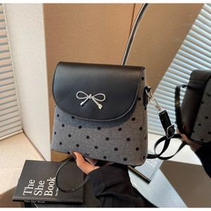 Détail du sac bandoulière gris à pois avec boucle nœud en métal argenté et rabat