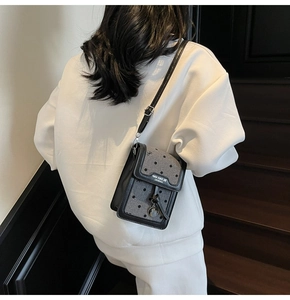 Gros plan d'un mini sac à bandoulière à pois avec bordure en cuir et nœud élégant