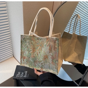 Close-up of floral embroidery on linen tote bag with cream rope handles and magnetic snap