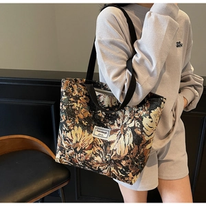 Detail of sunflower jacquard tote bag with wide straps and brand label on vintage fabric
