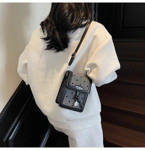 Vue détaillée du mini sac de téléphone rétro avec motif à pois gris et bordure en cuir