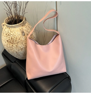 Pink large capacity hobo tote bag in a minimalist elegant home scene with leather chair