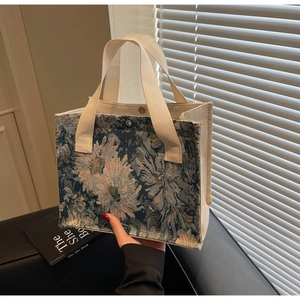Close-up of floral jacquard embroidery tote bag with cream canvas handle and magnetic clasp