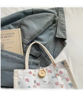 Close-up of floral fabric handbag with woven rope handles and a large wooden button detail
