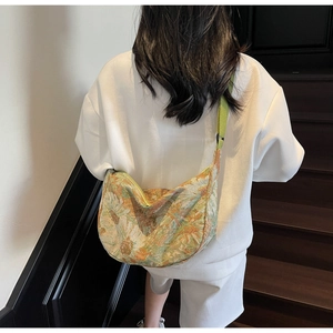 Detail of vintage floral jacquard tote with green adjustable strap shown on shoulder