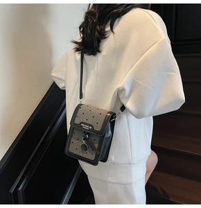 Détail d'un mini sac de téléphone rétro avec tissu à motif cœur et pendentif en métal