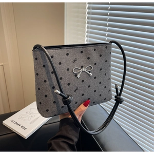 Detail of grey felt tote bag with black polka dots and silver bow charm