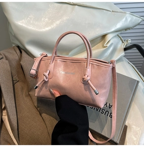 Détail du sac cabas en cuir rose avec texte Fashion Bag argenté et nœuds métalliques