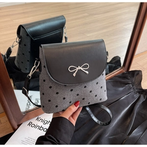 Détail du sac en laine grise à pois noirs avec boucle en métal argenté en nœud