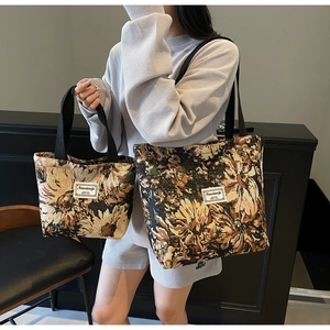 Detail showing two sizes of vintage floral tapestry tote bags with black canvas straps