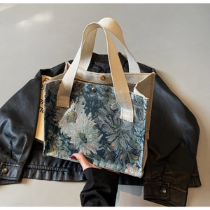 Detail of floral jacquard fabric and magnetic clasp on vintage style tote bag