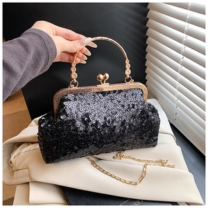Detail of black sequined evening clutch bag with gold round handle and chain strap