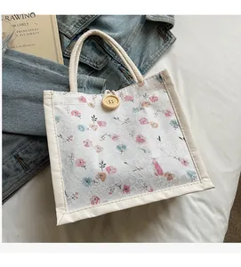 Detailed close-up of white floral lace handbag with rope handles and wooden button