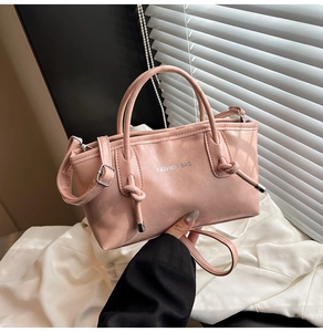Détail d'un grand sac cabas rose avec bandoulière réglable et tirette de zip nouée