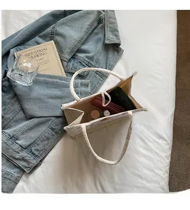 Top-down view of a beige canvas tote bag showing spacious interior with phone and wallet