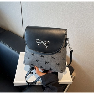 Détail du sac en tissu gris avec motifs de nœuds noirs et boucle argentée élégante
