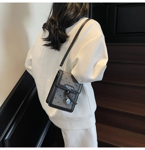 Détail d'un mini sac bandoulière avec motifs de cœurs et finitions en cuir raffiné