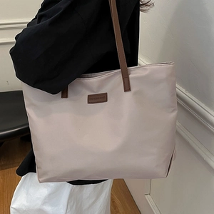 Minimalist large capacity nylon tote bag with brown leather straps for daily commuting