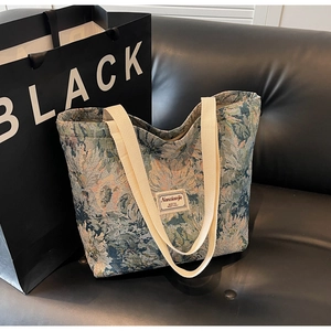 Close-up of vintage floral jacquard tote bag with intricate woven patterns and canvas handles