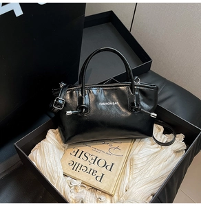Détail du sac cabas en cuir verni noir dans un coffret cadeau de luxe élégant