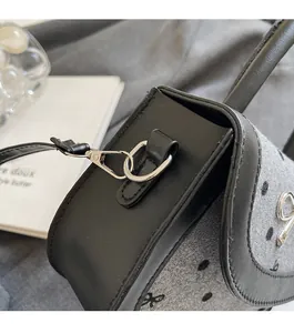 Detail of silver metal hardware and grey wool fabric on a bow pattern baguette bag