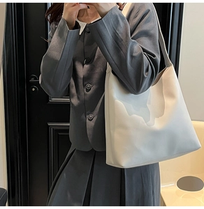Fashionable creamy white large capacity tote bag shown as a shoulder bag on a model