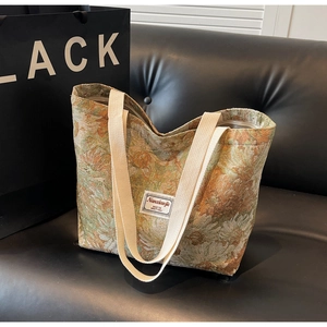 Detail of floral tapestry tote bag featuring woven texture and white fabric label