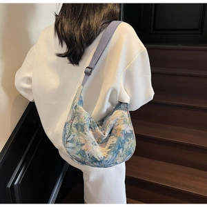 Detail view of the floral jacquard patterns on the crescent-shaped canvas tote bag