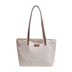 Large beige tote bag with brown leather handles and fashion tag for women's daily commute