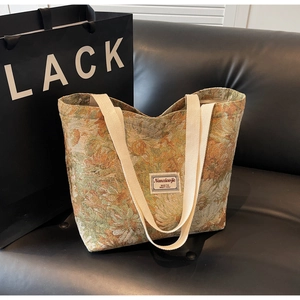 Detailed macro shot of vintage floral jacquard fabric and reinforced canvas strap on tote bag