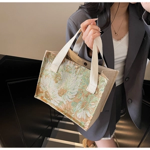 Detail of floral tapestry embroidery and cotton canvas strap on a vintage tote bag