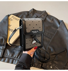 Gros plan détaillé d'un mini sac carré en toile grise avec motifs de cœurs noirs