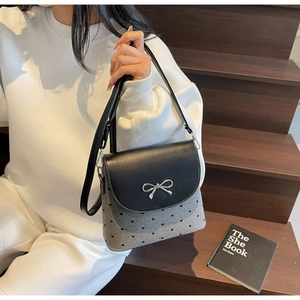 Détail de la boucle en nœud papillon et motif de cœur sur le sac à main en tissu gris
