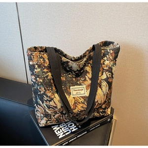 Close-up of colorful floral jacquard pattern and nice to meet you label on tote bag