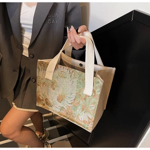 Detail of floral embroidery linen tote bag with cream strap shown in a modern setting