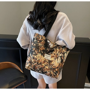 Detail of vintage floral jacquard tote bag with stylish black shoulder strap