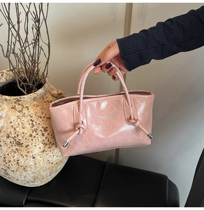 Gros plan du sac fourre-tout rose avec nœuds décoratifs et finitions métalliques élégantes