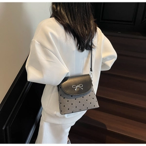 Détail de la boucle nœud argenté sur sac seau gris à pois avec rabat en cuir noir