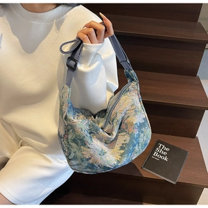 Detail of blue floral jacquard fabric with daisy patterns and adjustable shoulder strap