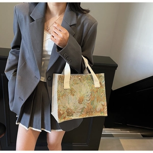 Artistic jacquard handbag with embroidered flower pattern shown with minimalist outfit