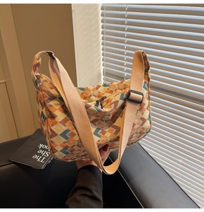 Detailed macro view of geometric diamond pattern canvas fabric on a crossbody bag